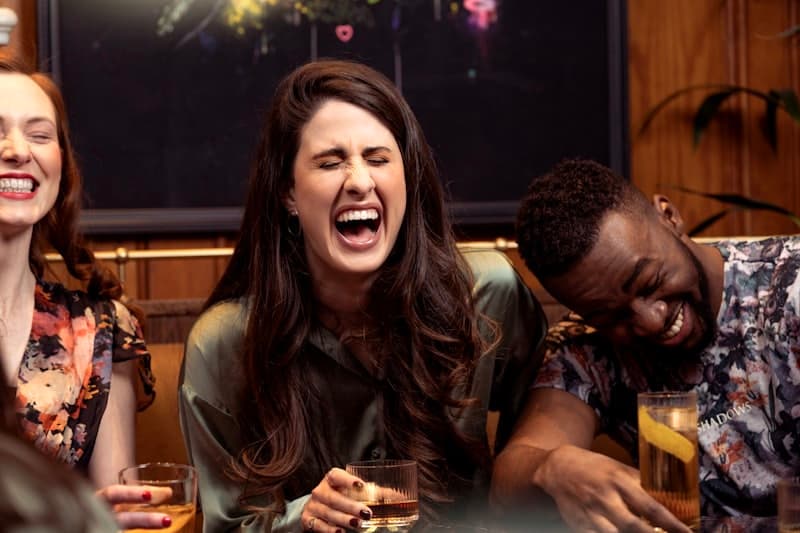 Friends laughing together over drinks